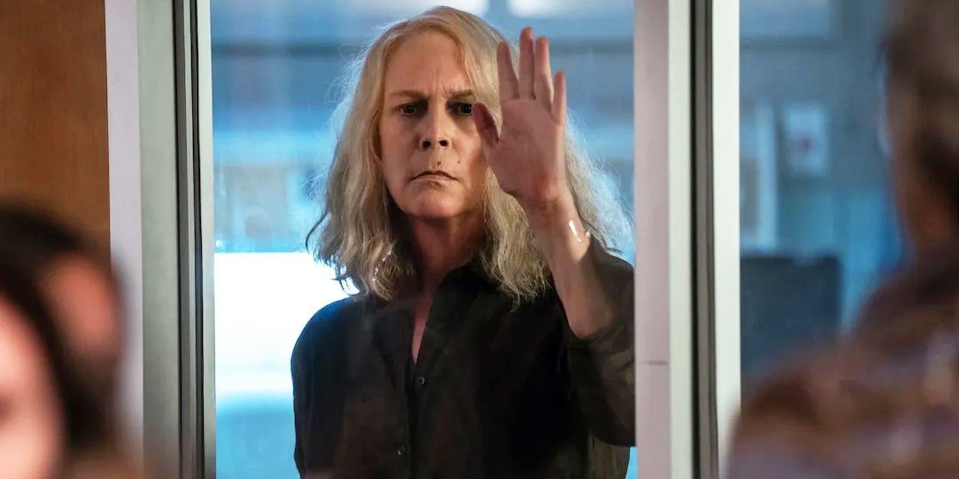 Halloween Ends: Jamie Lee Curtis' Laurie Strode faces the camera, pressing her hand on a glass door.
