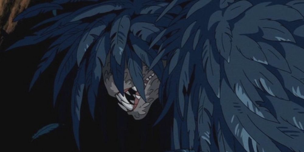 Howl stands in monster form in Howl's Moving Castle; a scary face enveloped by gray-blue feathers.