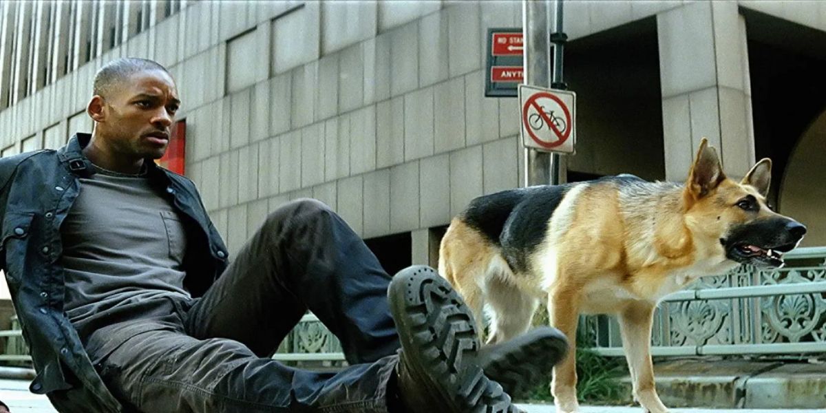 Will Smith as Robert in I Am Legend, lies in the middle of the street with his dog by his side.