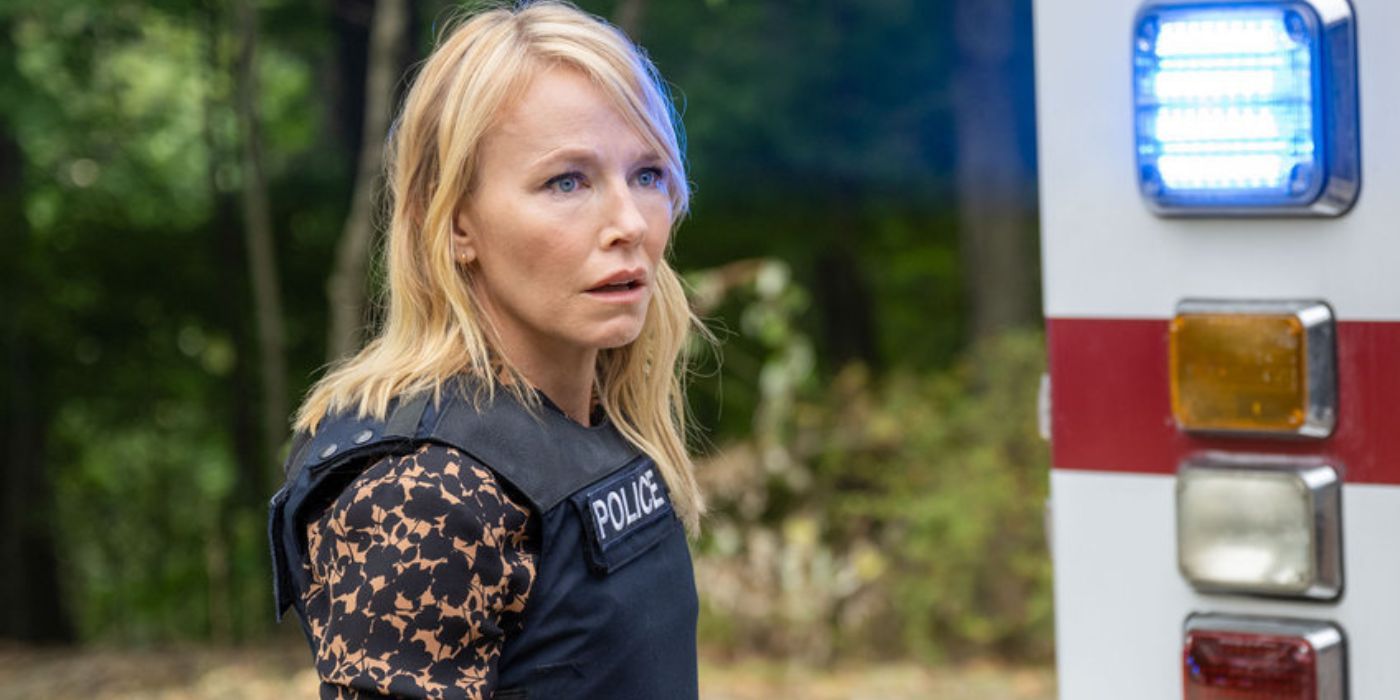 Law & Order: Amanda Rollins do SVU, interpretada por Kelli Giddish, em um colete da polícia ao lado de uma ambulância