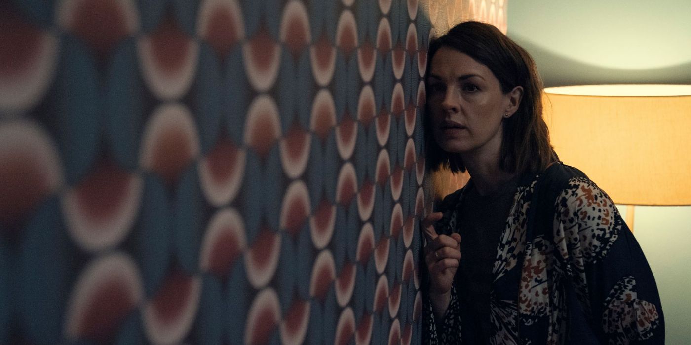 Jessica Raine as Lucy with her ear against the wall in the Devil's Hour on Amazon Prime