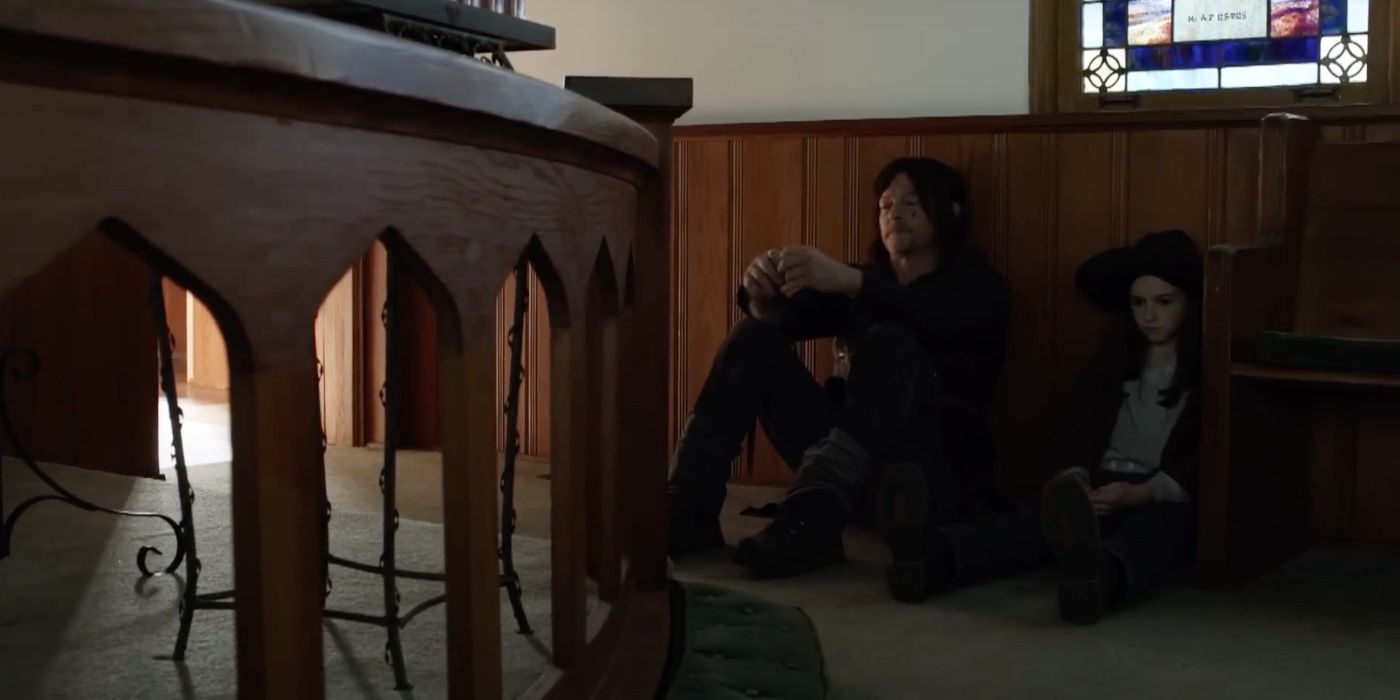 Daryl and Judith sitting together on the floor against a wall in The Walking Dead