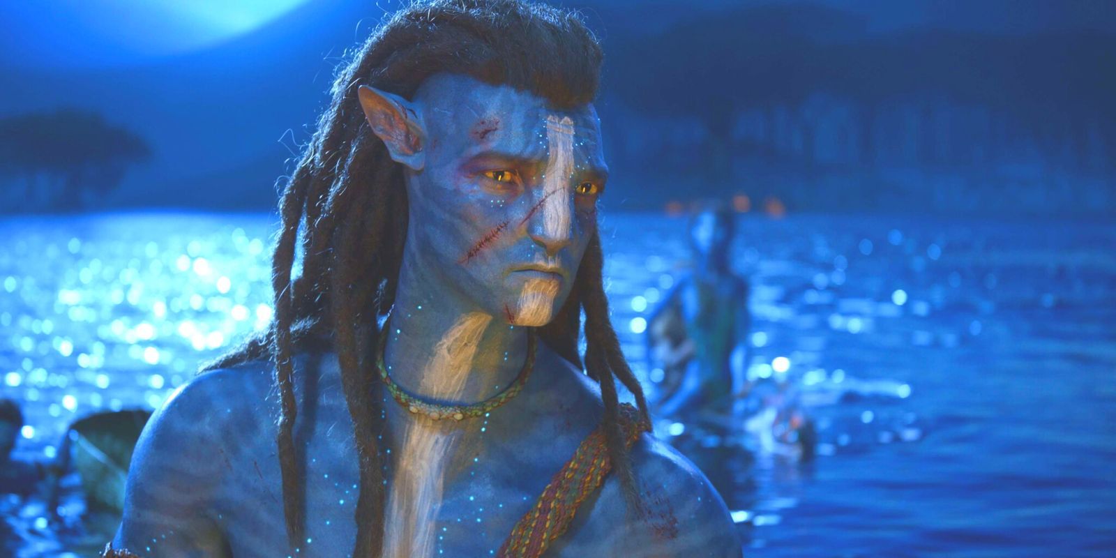 Jake Sully looking concerned while standing on a moonlit beach in Avatar: The Way of Water