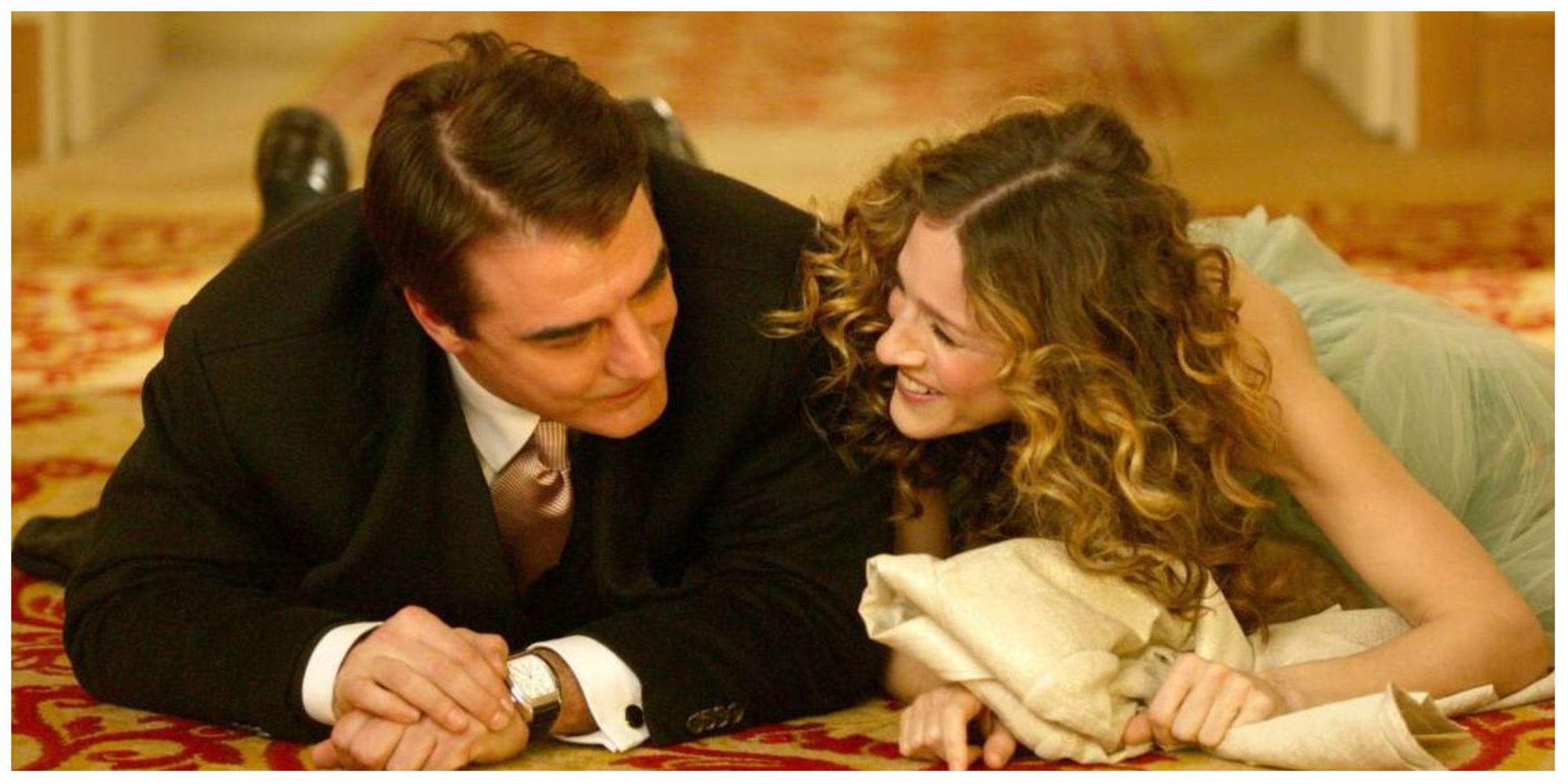 Carrie Bradshaw and Mr. Big smiling and lying down in Sex and The City.
