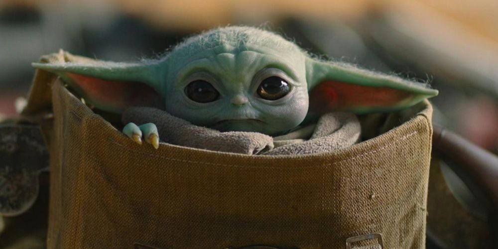 Grogu Baby Yoda sitting in a bag in The Mandalorian Star Wars