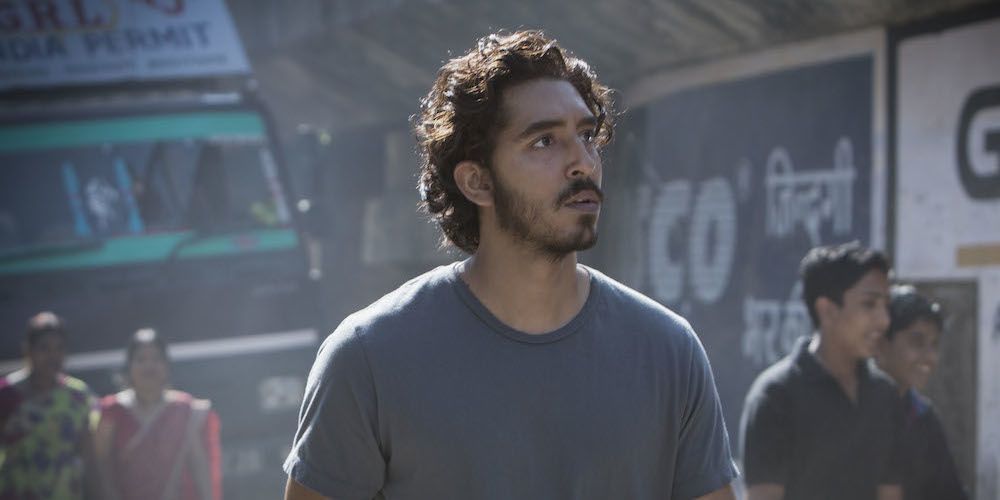 Dev Patel stands on a street in Lion