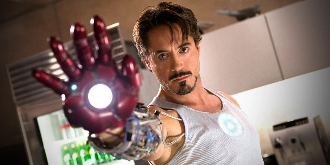 Robert Downey Jr as Tony Stark holding out Iron Man hand prototype in 2008's Iron Man