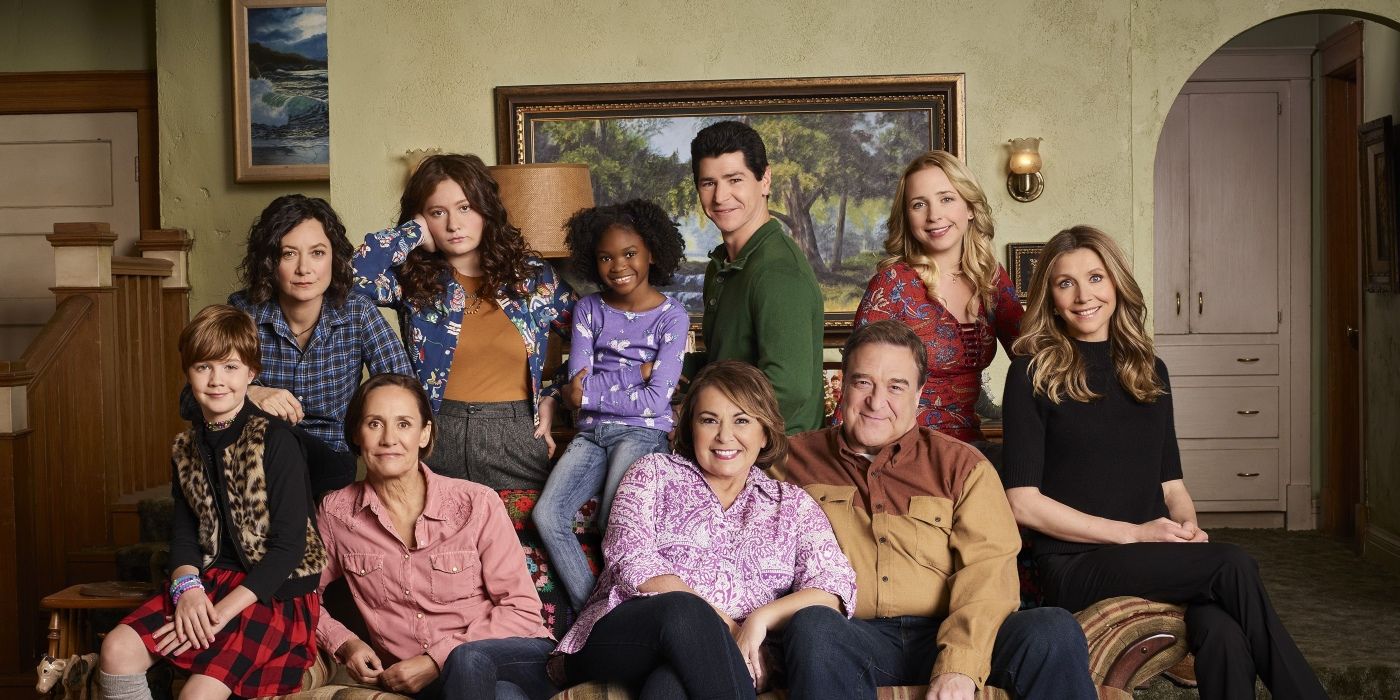 The cast of the Roseanne reboot sitting on a couch, including Roseanne Barr.