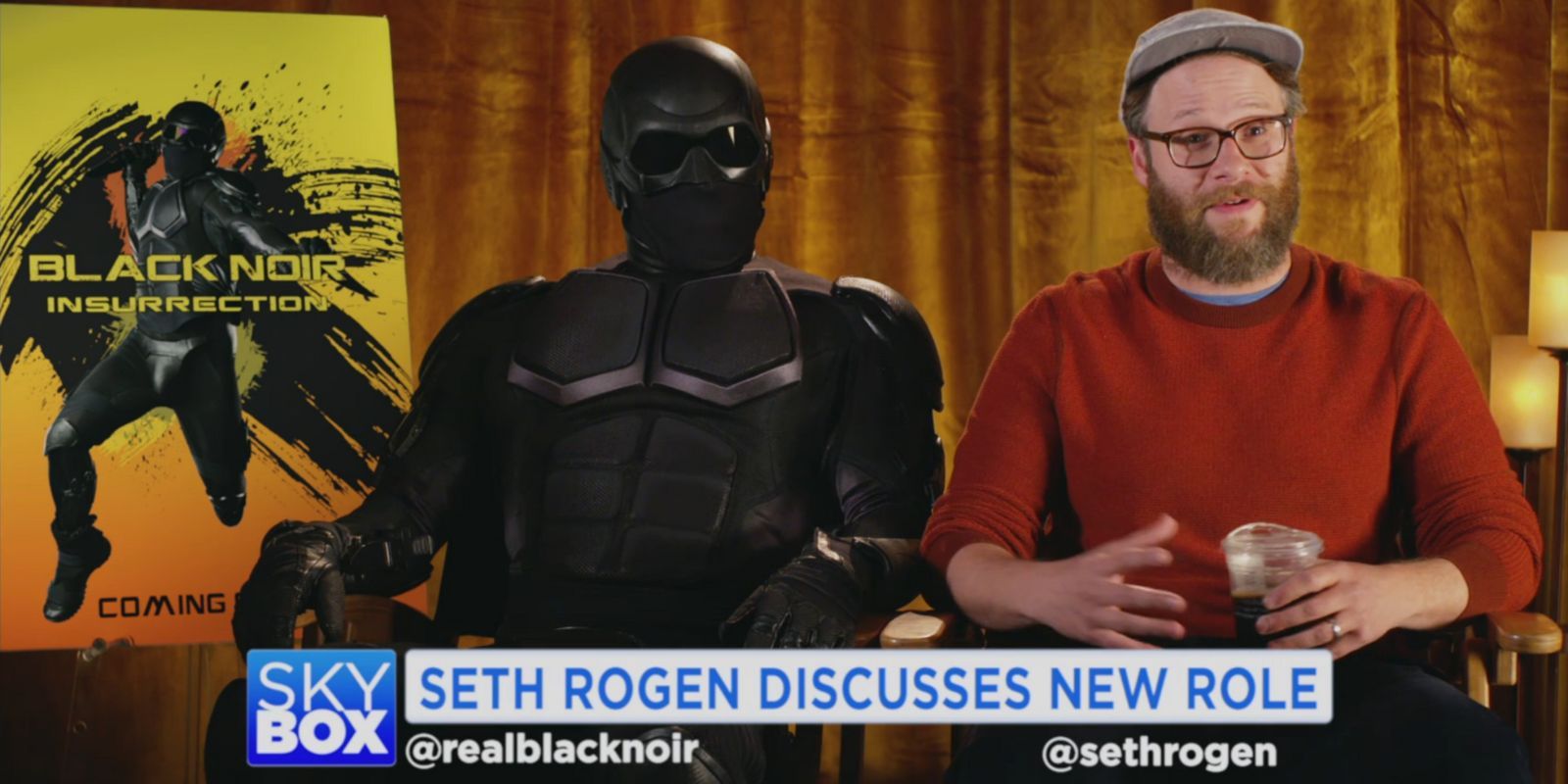 Seth Rogen sits next to Black Noir in The Boys
