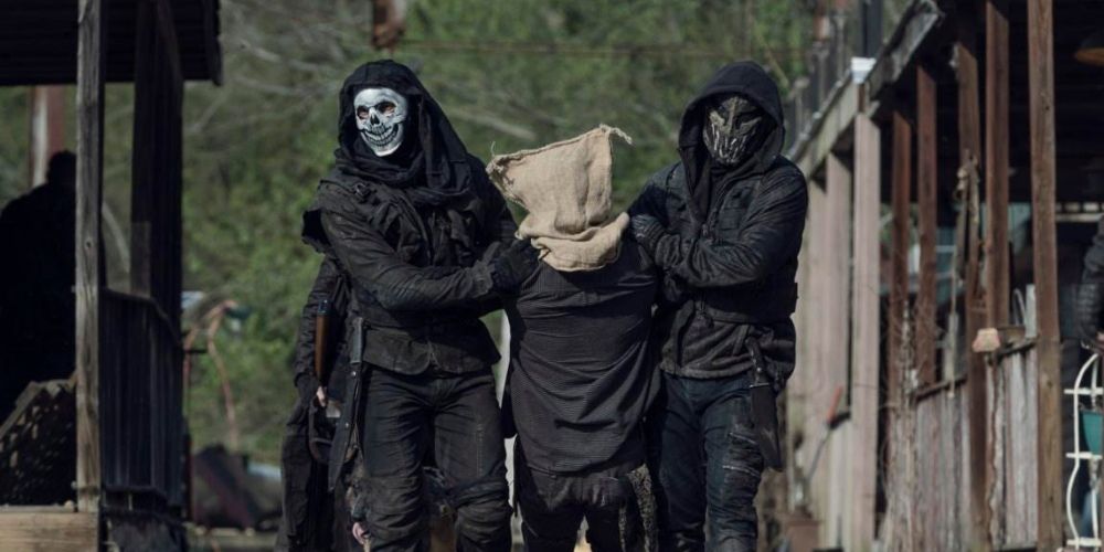 Two Reapers escorting a hostage in The Walking Dead