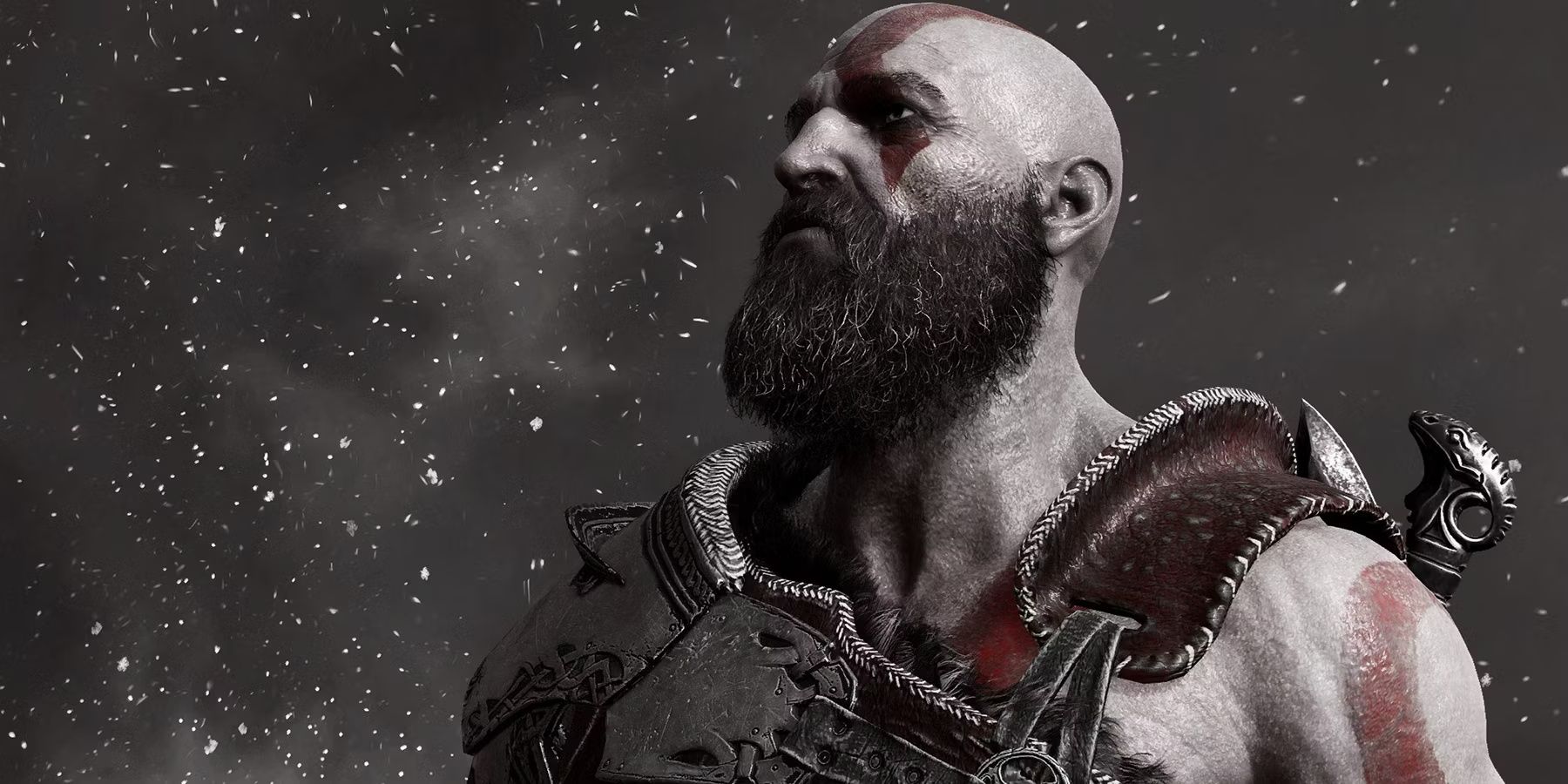 Kratos looking up into the snowfall in God of War (2018)