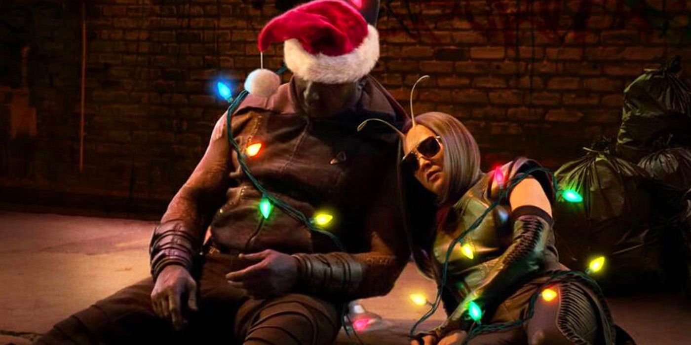 Guardians of the Galaxy Holiday Special poster: Mantis and Drax sleep something off in an alley, wrapped in glowing Christmas lights.