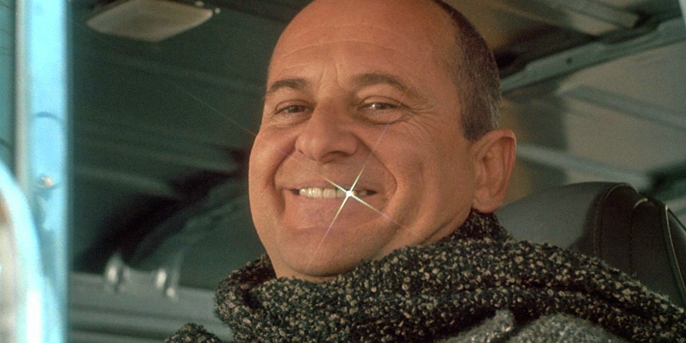 Joe Pesci as Harry in Home Alone smiling as his gold tooth gleams.