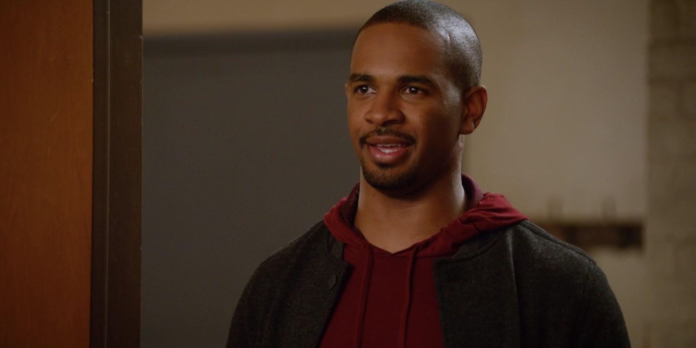 Coach from New Girl (played by Damon Wayans Jr.) smiles while stood in a door frame