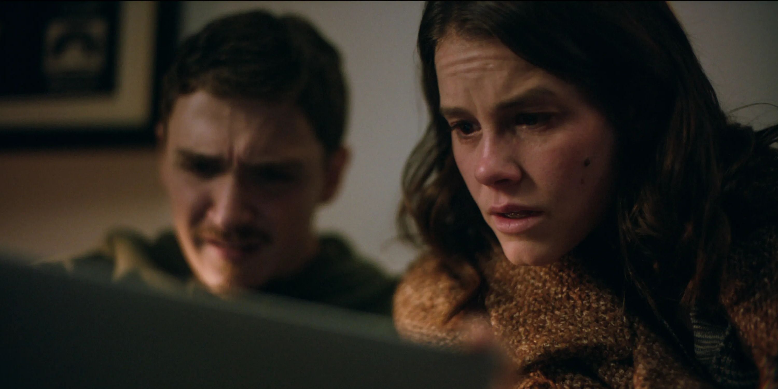 Joel and Rose look scared at a screen in Smile