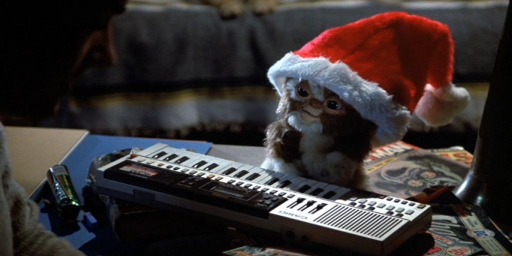 Gizmo in a santa hat by the keyboard