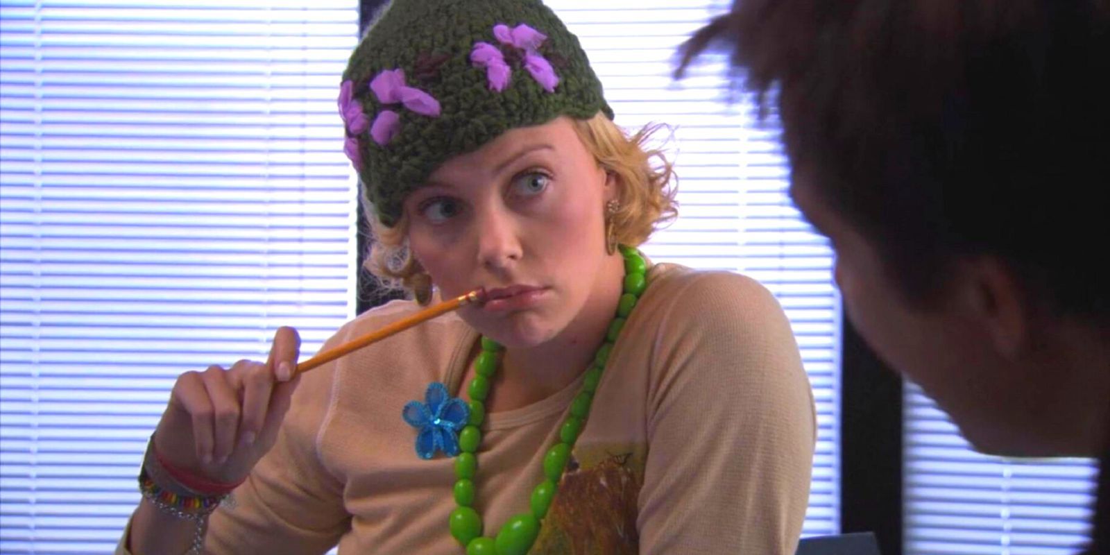 Charlize Theron in Arrested Development holding a pencil to her mouth