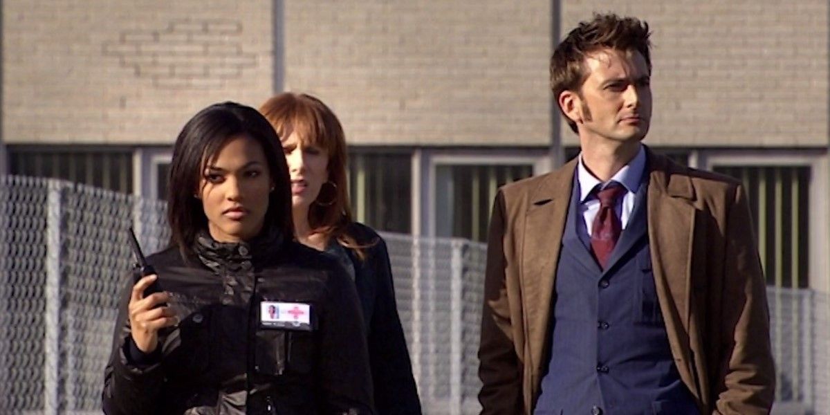 Martha Jones stands in front of Donna Noble and the Tenth Doctor in Doctor Who
