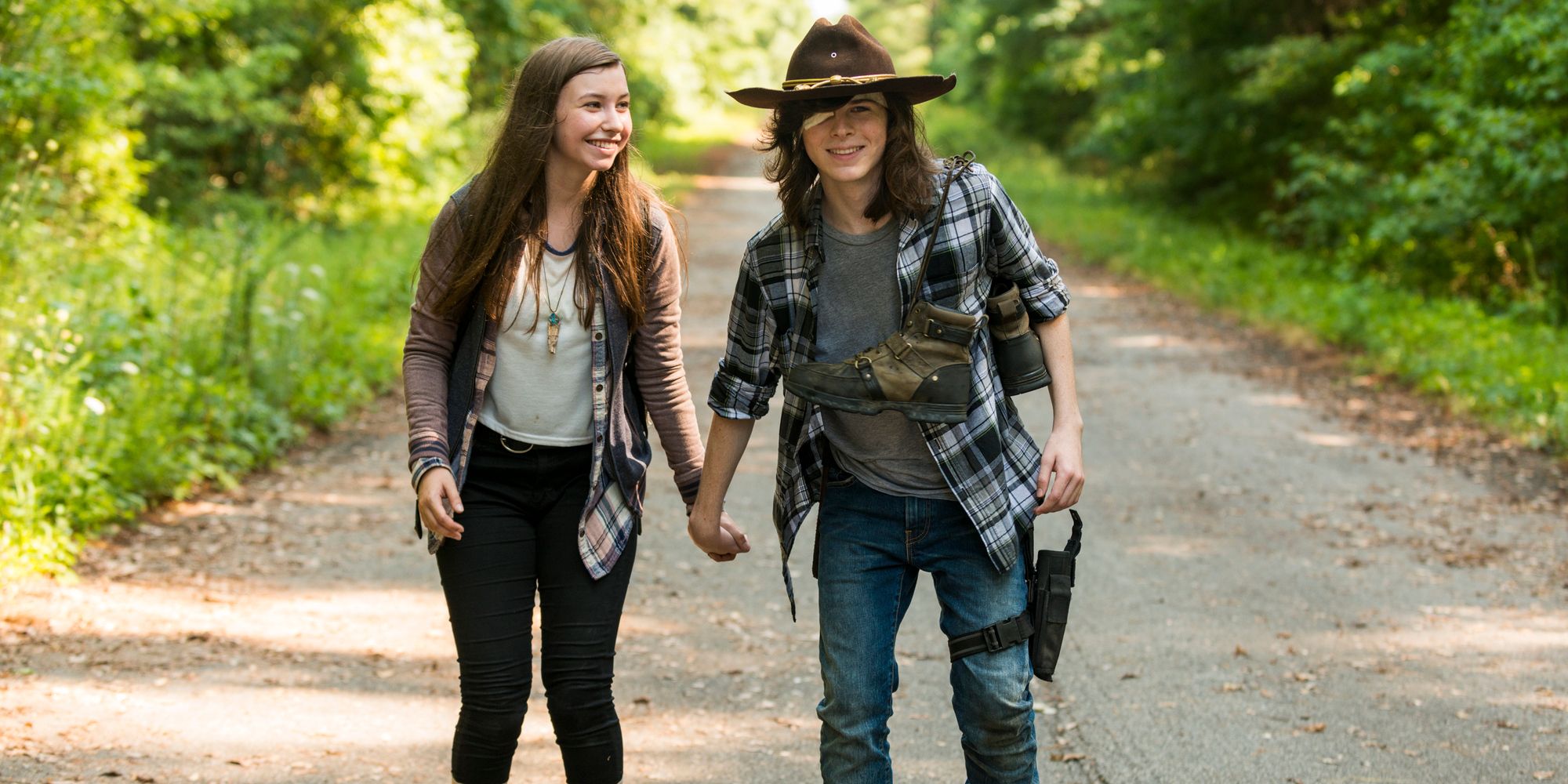 Enid and Carl hold hands while roller skating in Go Getters in The Walking Dead