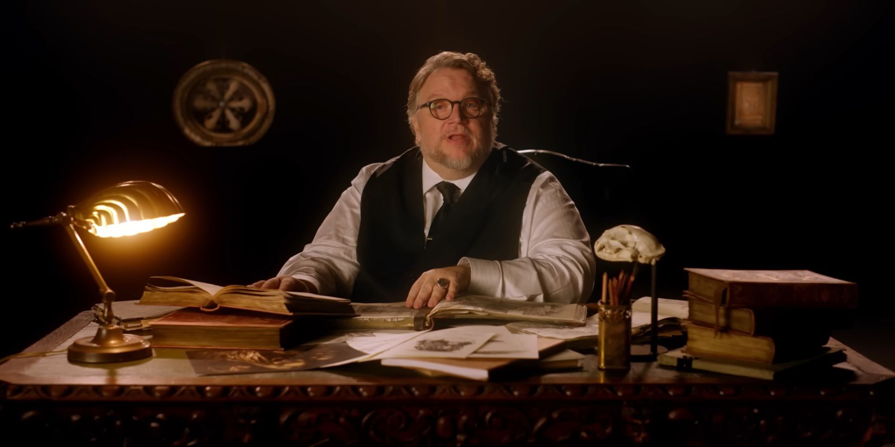 Guillermo del Toro introducing his Cabinet of Curiosities from a vintage desk