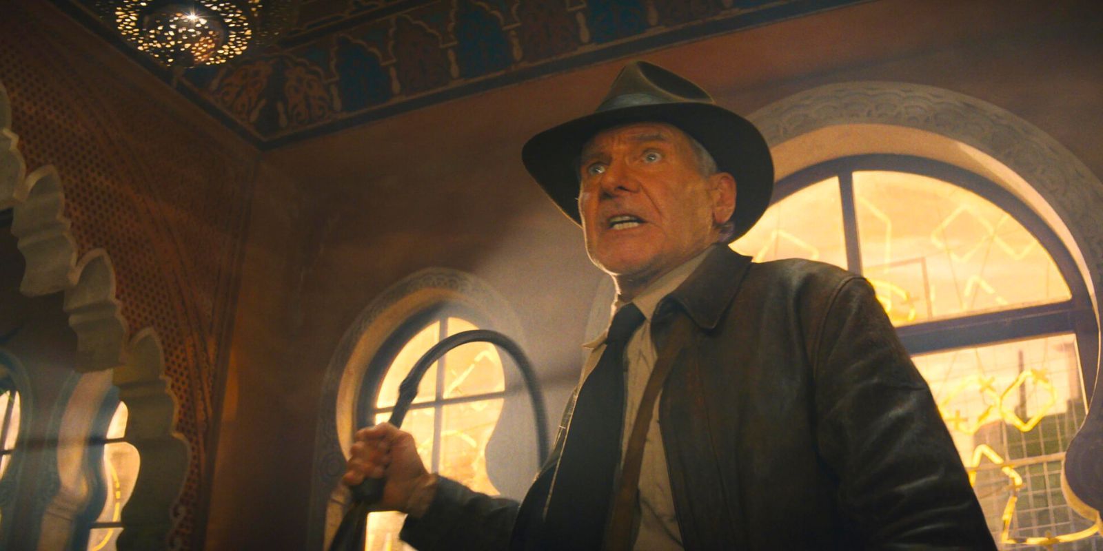 Indiana Jones, whip in hand, snarling at a group of thugs