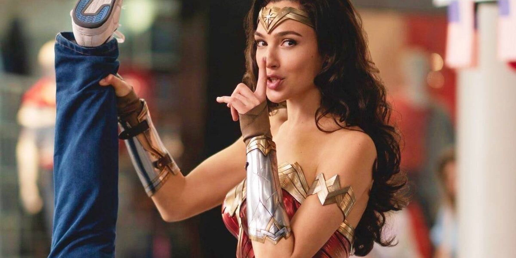A scene from Wonder Woman: 1984 where Wonder Woman (Gal Gadot) holds a criminal by the leg.