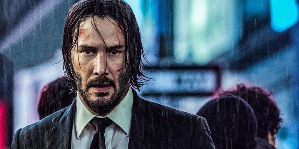 John Wick stares ahead in the rain in John Wick