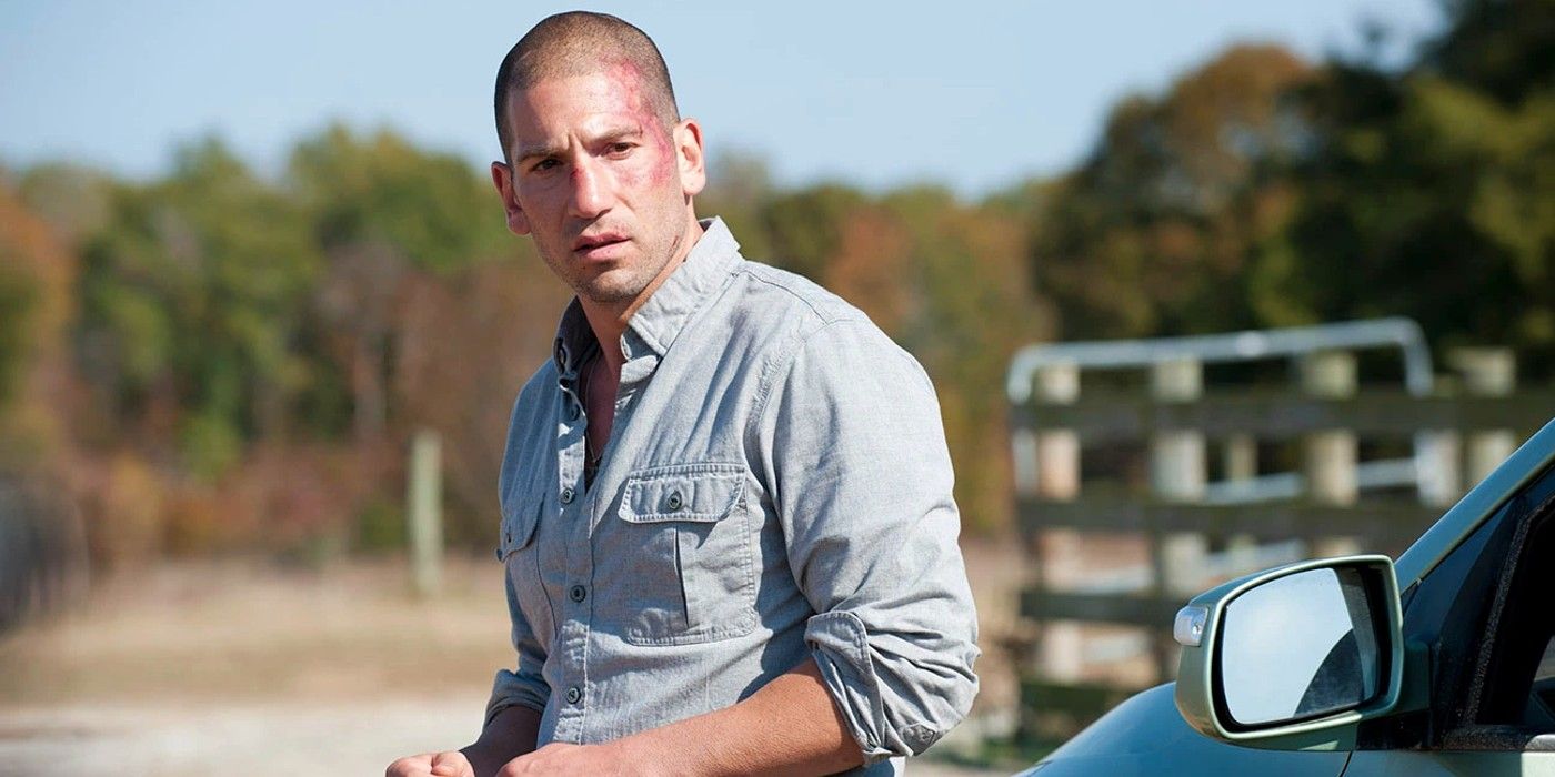 Shane Walsh stands next to a car