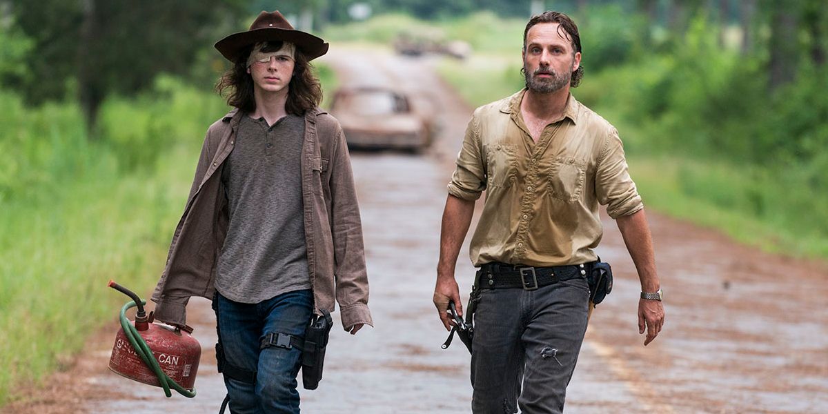 Carl (Chandler Riggs) carries a gas cannister while walking alongside Rick (Andrew Lincoln) on The Walking Dead.