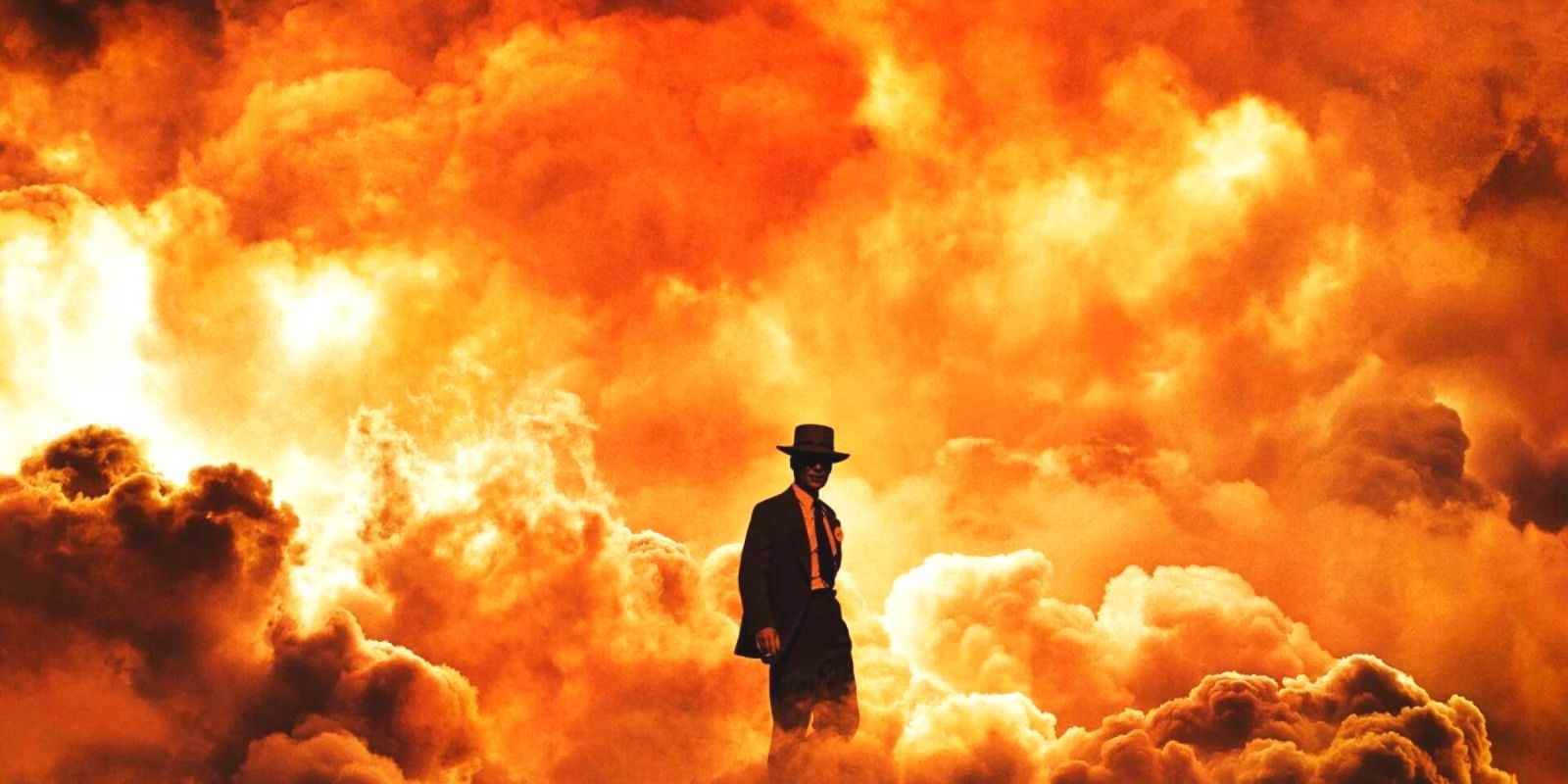 A man in suit standing in front of orange smoke clouds in Oppenheimer