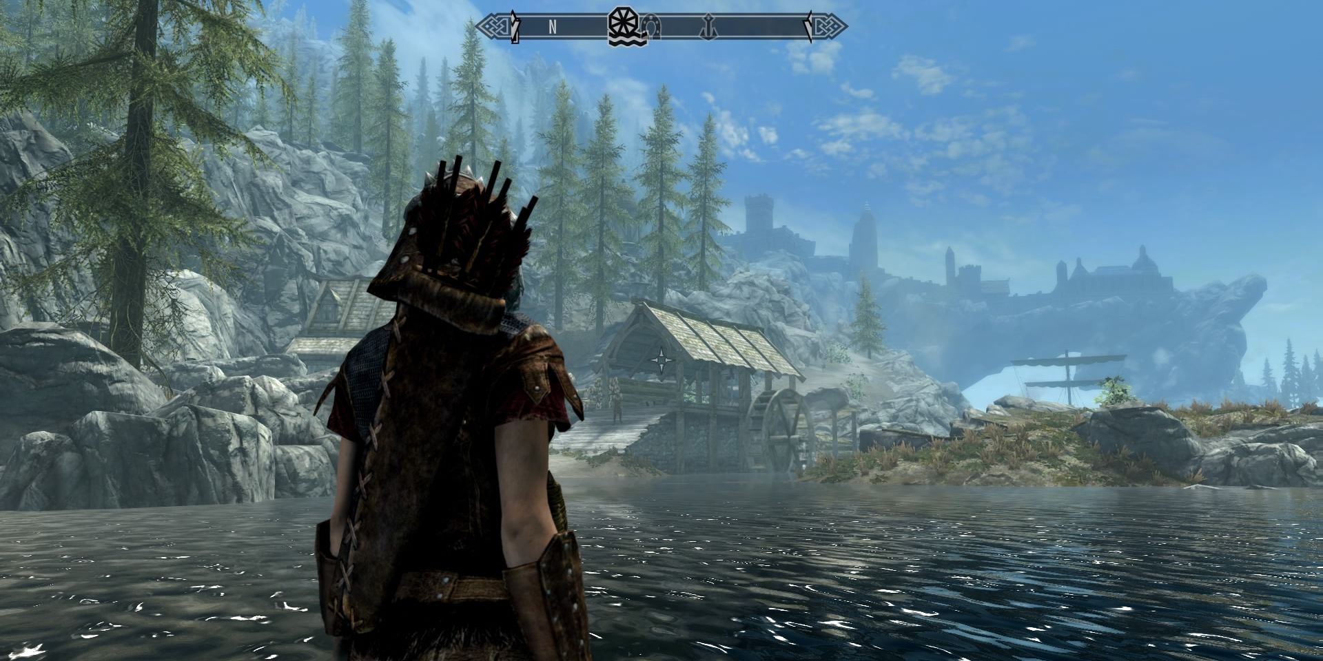 Player overlooks a pond with a shack across the way in The Elder Scrolls V Skyrim Special Edition