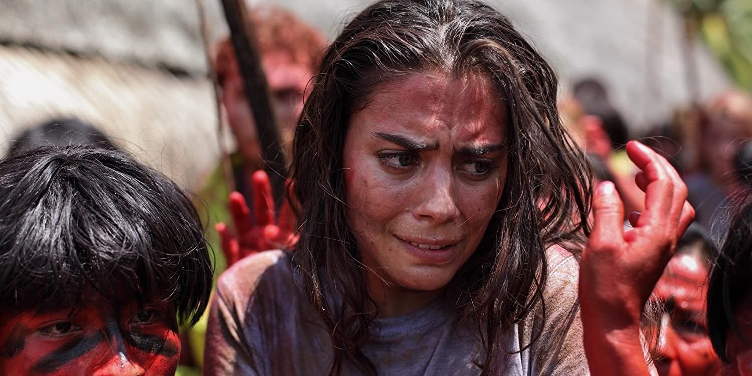Justine looks scared as bloody tribe members reach for her in The Green Inferno.
