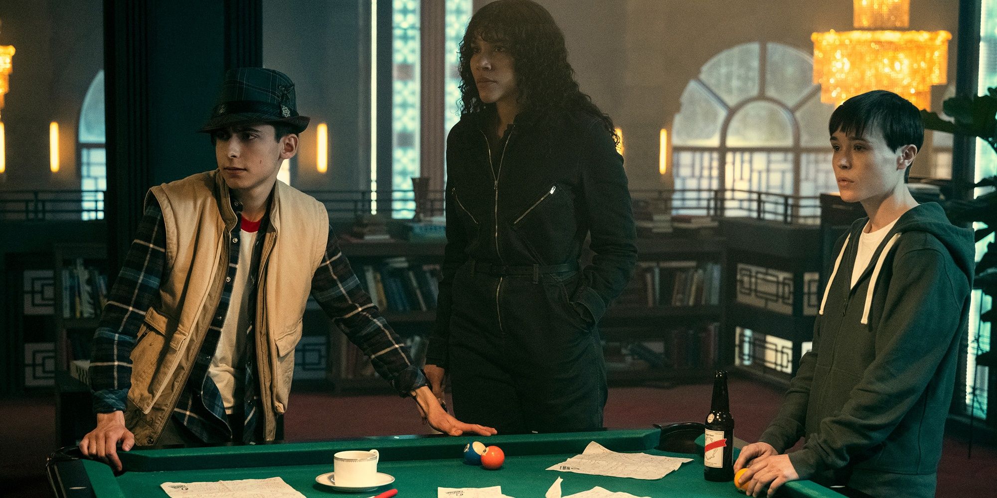 Three people by a pool table in The Umbrella Academy 