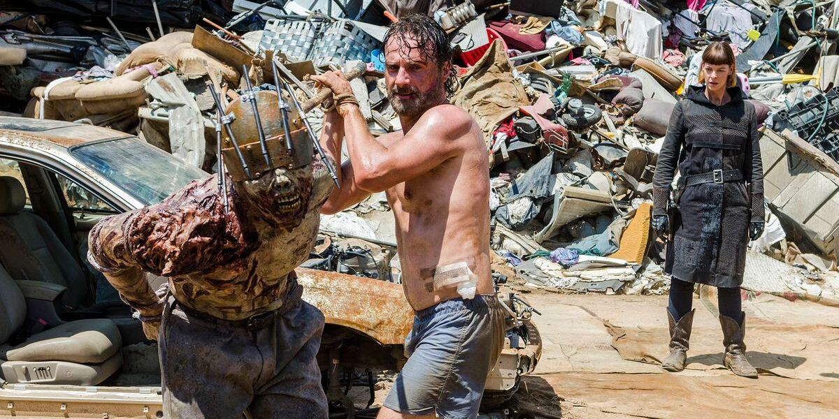 A shirtless Rick (Andrew Lincoln) tries to kill a walker as Jadis/Anne looks on in "Time For After" in The Walking Dead