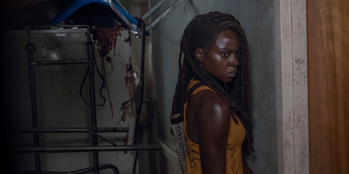 Michonne from The Walking Dead standing up against a wall, looking ready to fight.