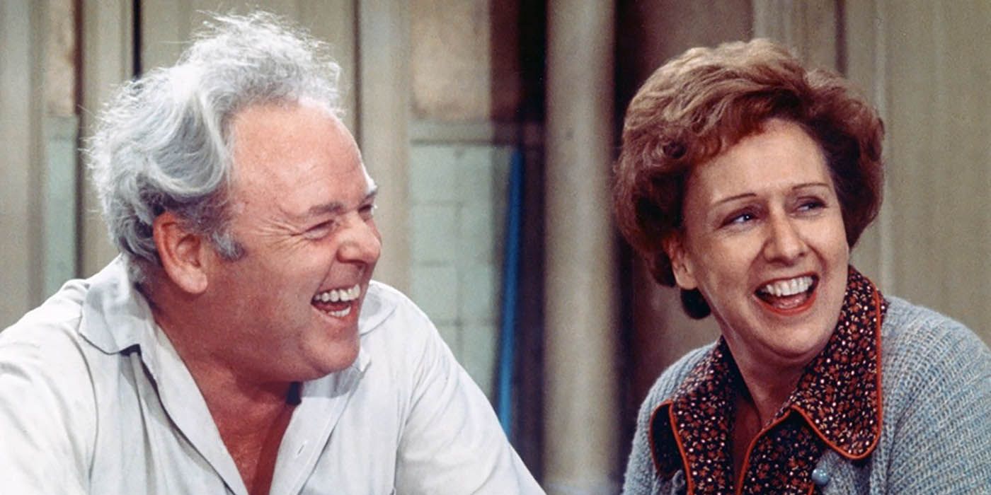 Archie and Edith Bunker laughing in a scene from All in the Family.