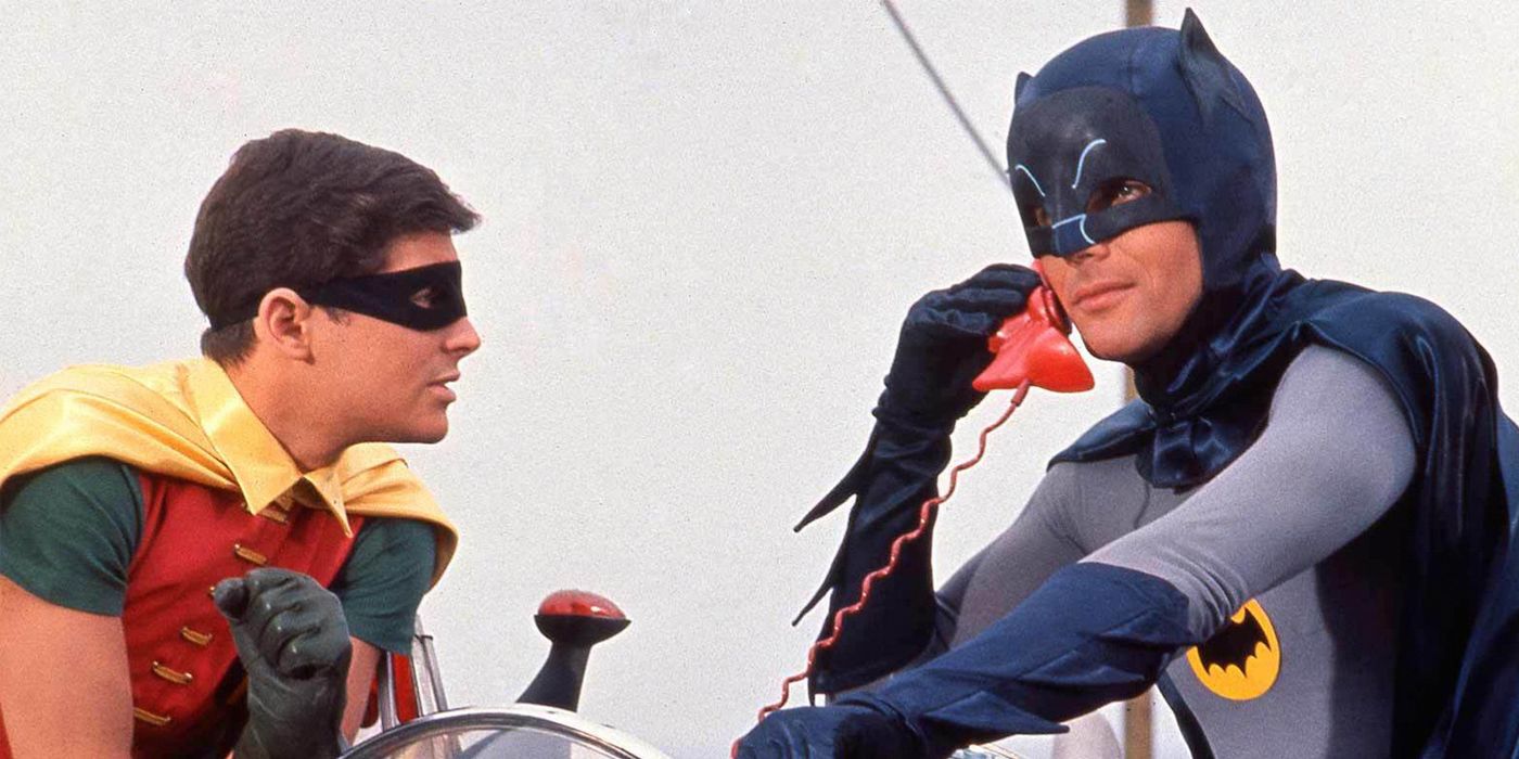 Adam West's Batman talks on the phone with Burt Ward's Robin at his side
