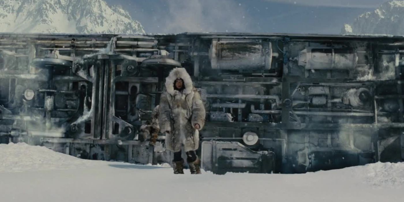 Um homem caminha perto de um trem descarrilado no filme Snowpiercer