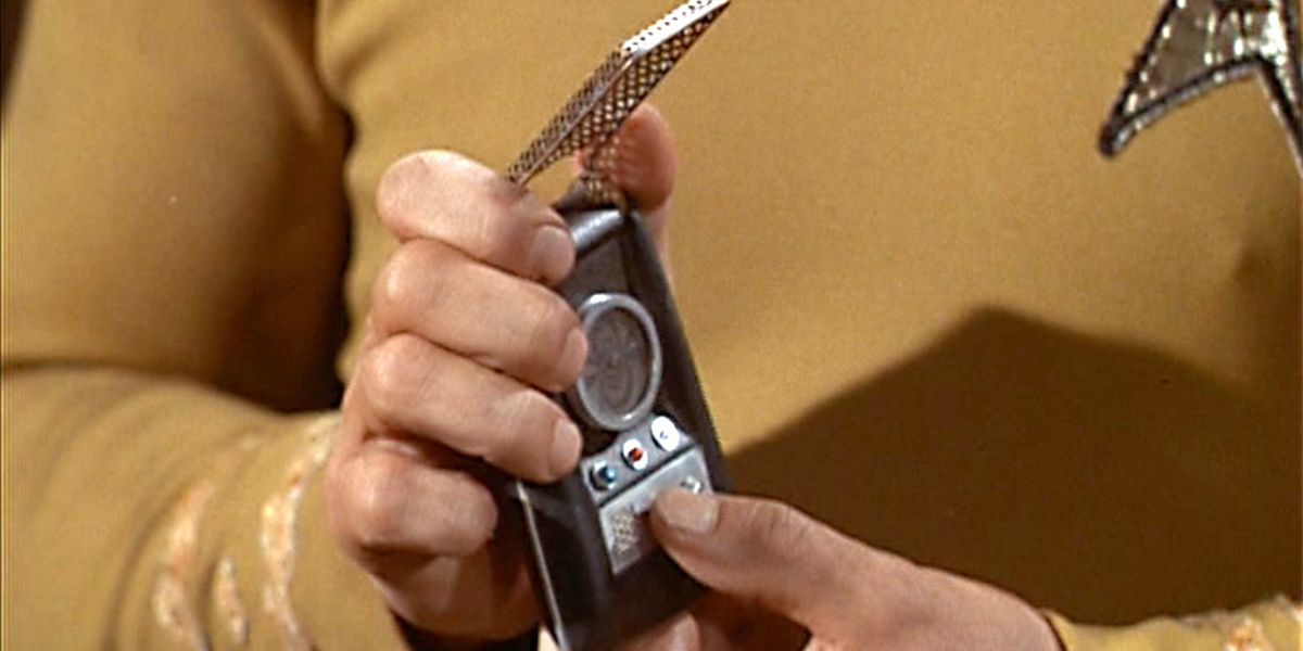 Captain Kirk holds a communicator on Star Trek, the original series.