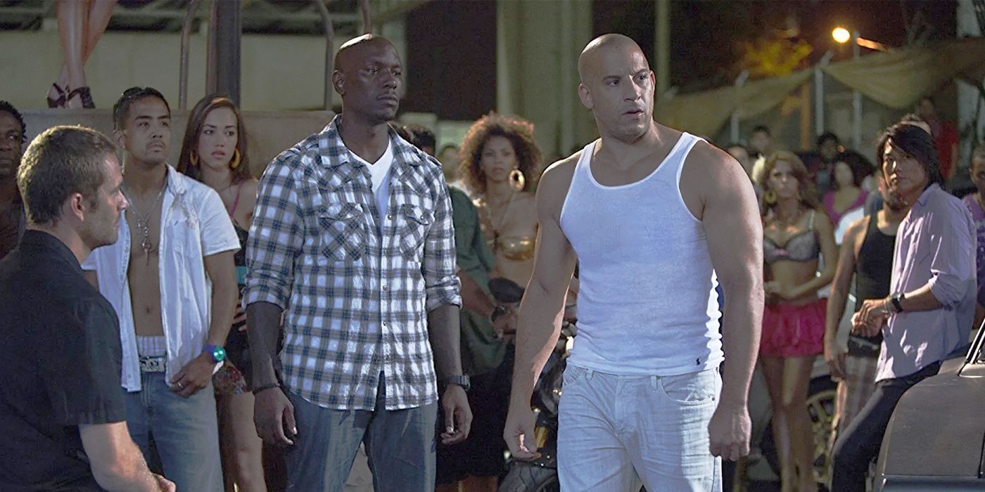 Roman and Dominic standing among racers in Fast and Furious