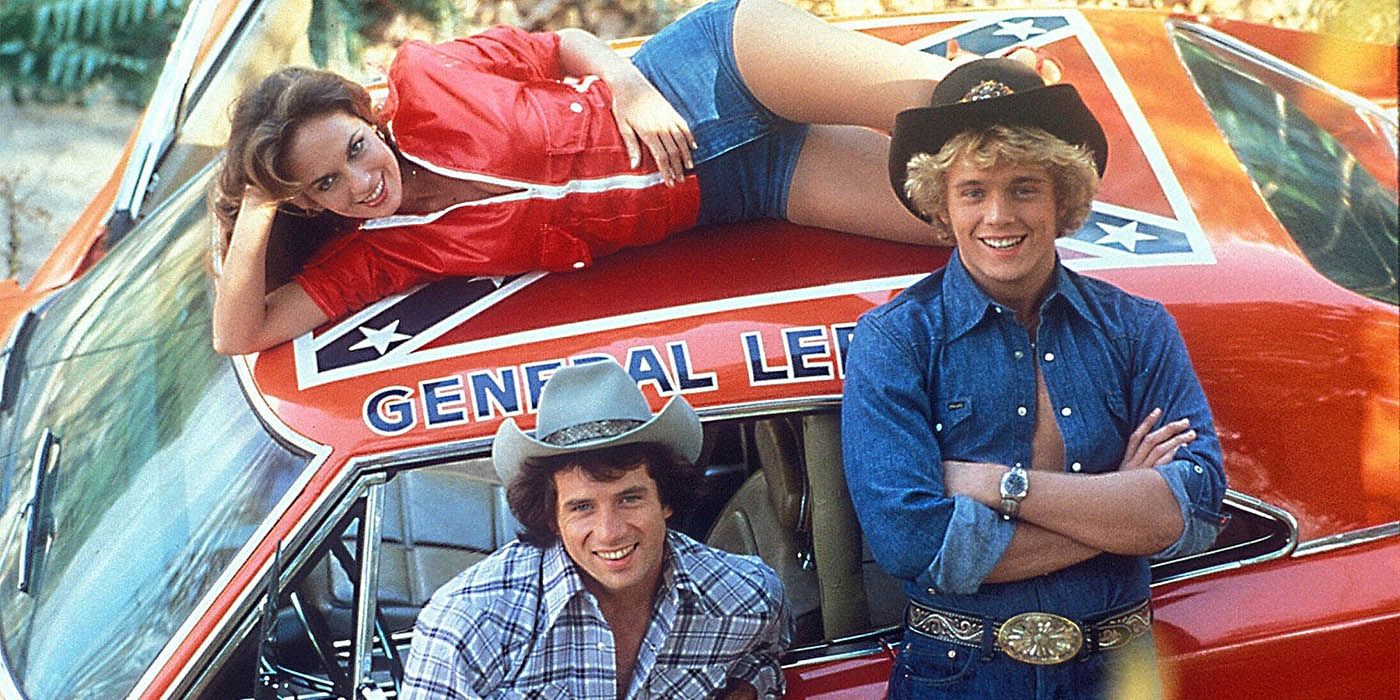 The Dukes of Hazzard characters standing around their car.