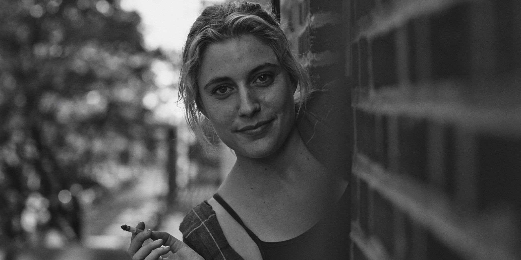 Greta Gerwig em Frances Ha olhando em uma esquina com um cigarro