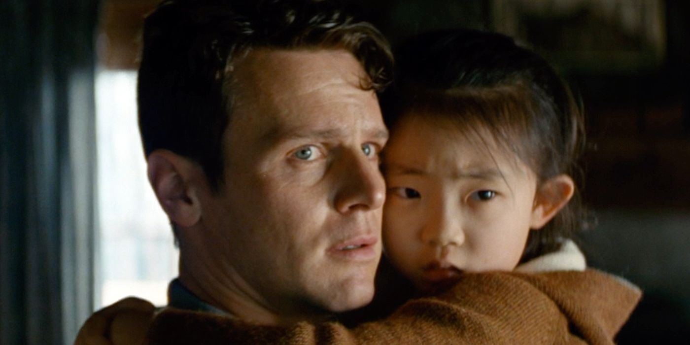 Jonathan Groff as Eric, holding his daughter Wen, in Knock at the Cabin