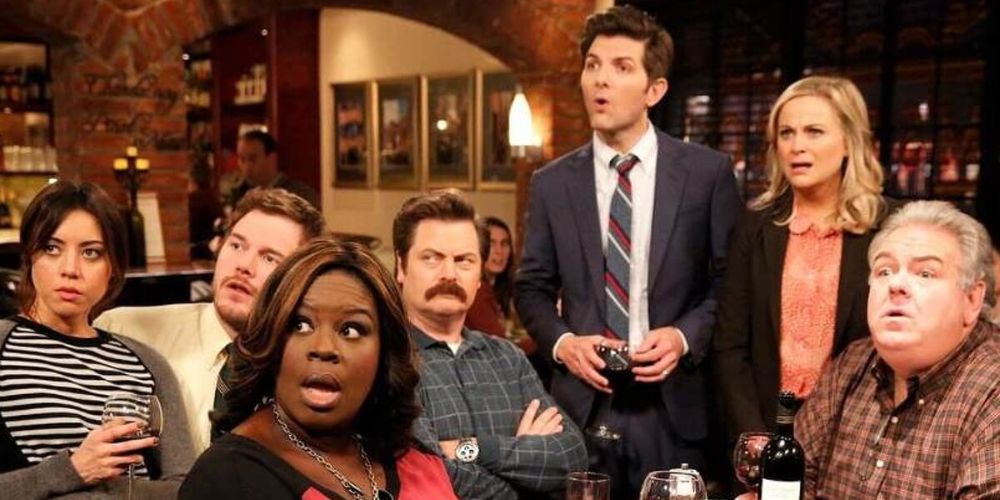 The cast of Parks And Recreation looks shocked in a still from the show.