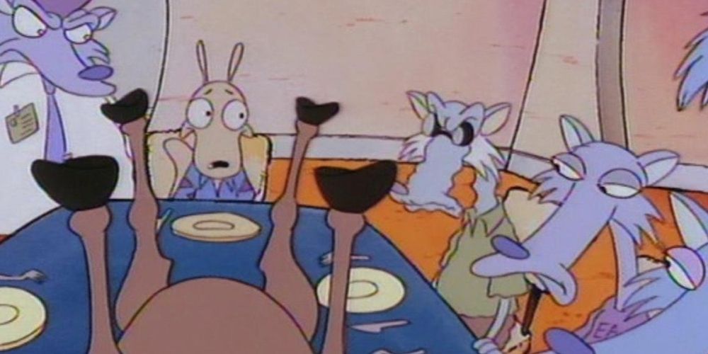 ภาพหน้าจอของ Rocko's Modern Life - Who's For Dinner - Rocko นั่งอยู่ที่โต๊ะอาหารค่ำ ล้อมรอบด้วยหมาป่าขี้โมโห