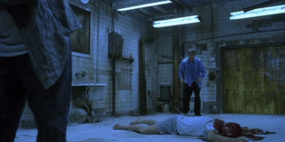 The two victims standing around Jigsaw's body in Saw