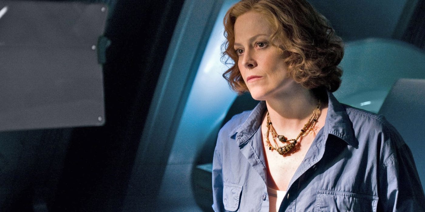 Sigourney Weaver in the first Avatar film, pictured wearing a blue button down and an ornate brown necklace
