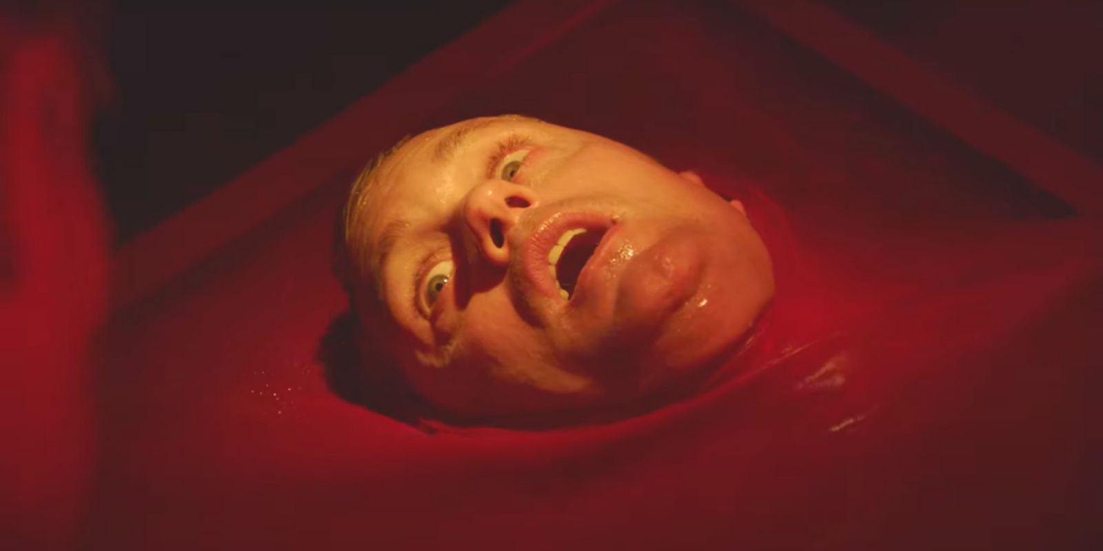 Alexander Skarsgard sinking into a pool of blood in Brandon Cronenberg's Infinity Pool