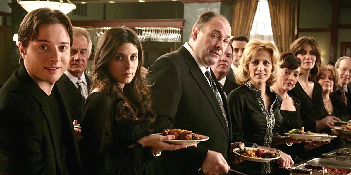 Tony Soprano, interpretado por James Gandolfini, está comendo junto com sua família em The Sopranos.