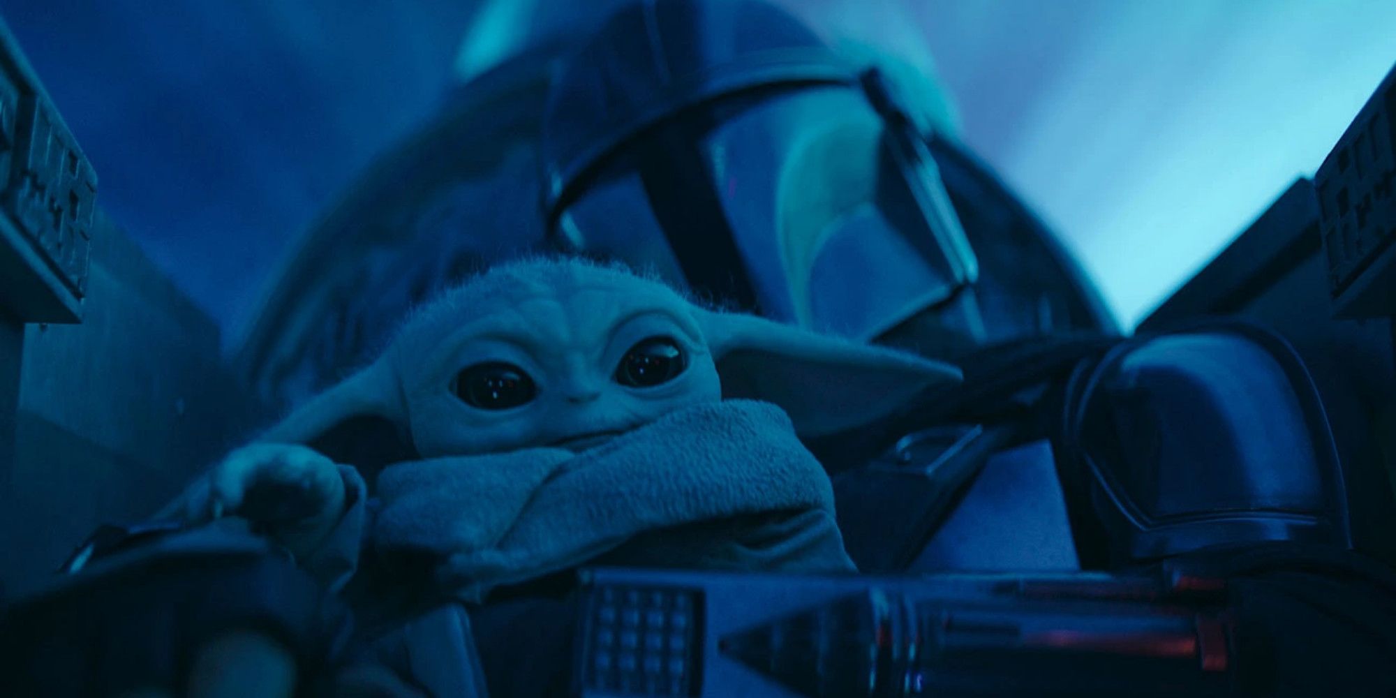 The Mandalorian Season 3: Din Djarin holds Grogu/Baby Yoda while sitting in the cockpit of his Naboo starfighter.